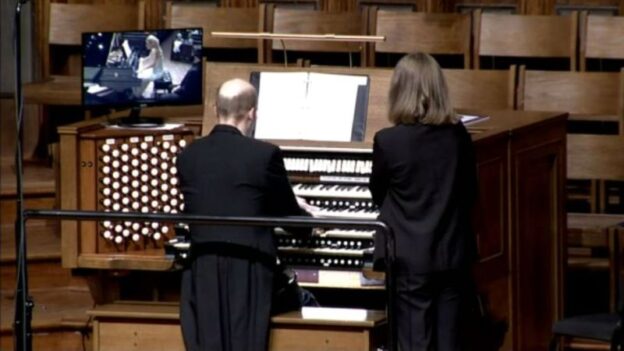 Jens Korndörfer at the organ console, with a video monitor to his left in which pianist Julie Coucheron can be seen as they perform together. (image: FPCA)
