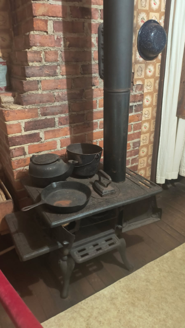 Although most of the furnishings inside the Presley home are only representative, some are original: this stove, the coal-burning fireplace (which faces the other room), and the flooring seen here are original, as is the overall structure. (credit: Mark Gresham, April 4, 2026)