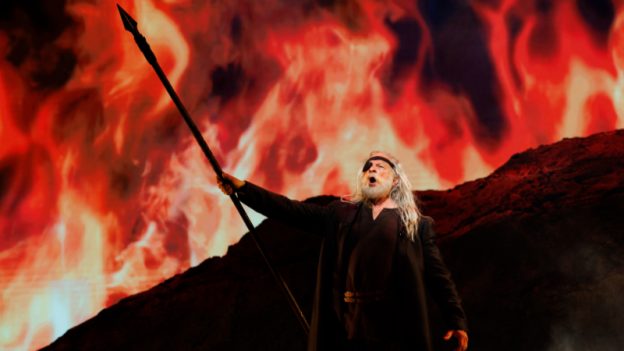 In The Atlanta Opera’s 2024 production of ‘Die Walküre,’ Greer Grimsley as Wotan stands before the ring of fire that imprisons Brünnhilde — a defining image of divine power and punishment within Wagner’s Ring cycle that also foreshadows the elemental conflagration and collapse that bring the saga to its conclusion in ‘Twilight of the Gods.’ (credit: Raftermen)